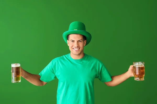 Jongeman met bier op kleur achtergrond. St. Patrick 's Day viering — Stockfoto