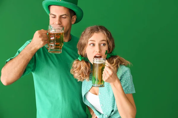 Young couple with beer on color background. St. Patrick's Day celebration — 스톡 사진