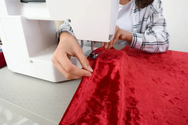Mujer joven cosiendo ropa en atelier, primer plano — Foto de Stock