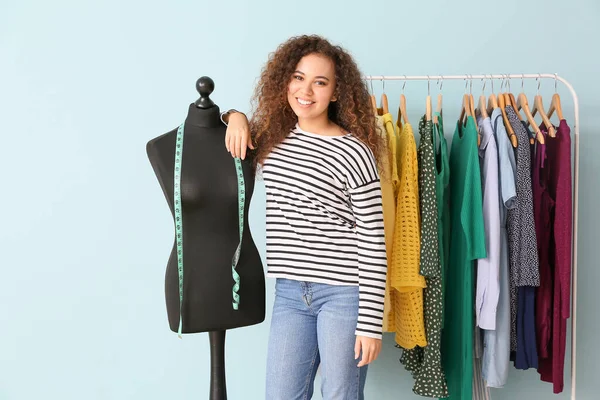 African-American stylist near mannequin and rack with modern clothes — Stock Photo, Image
