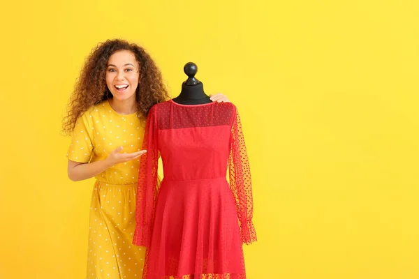 African-American stylist with mannequin on color background — Stock Photo, Image