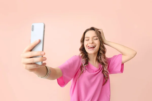 Mujer joven tomando selfie sobre fondo de color — Foto de Stock