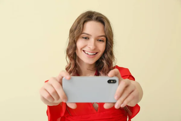 Mujer joven tomando selfie sobre fondo de color — Foto de Stock