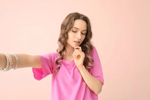 Mujer joven tomando selfie sobre fondo de color —  Fotos de Stock