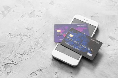 Grunge arka planında cep telefonu olan kredi kartları. Çevrimiçi bankacılık kavramı
