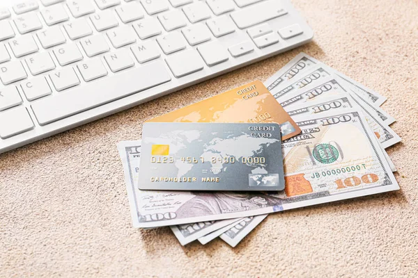 Gri arka planda para ve bilgisayar klavyesi olan kredi kartları. Çevrimiçi bankacılık kavramı — Stok fotoğraf