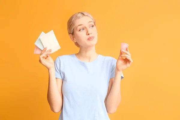 Молодая женщина с менструальными чашками и прокладками на цветном фоне — стоковое фото