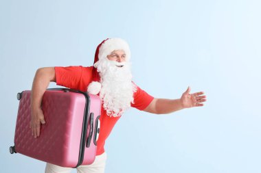 Arka planda bavulu olan Noel Baba 'yı çalıştırmak. Tatil kavramı