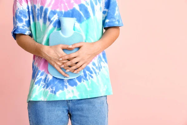 Young woman suffering from menstrual cramps on color background — ストック写真