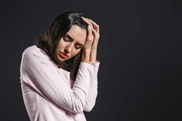 Mujer joven deprimida sobre fondo oscuro — Foto de Stock