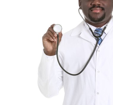 Beyaz arka planda steteskobu olan Afrikalı Amerikalı bir erkek doktor.