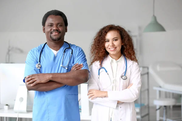 Jonge Afro-Amerikaanse arts en mannelijke verpleegkundige in kliniek — Stockfoto