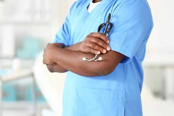Mannelijke Afro-Amerikaanse verpleegster met stethoscoop in kliniek — Stockfoto