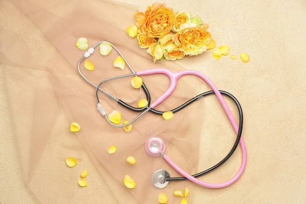 Stethoscope with flowers on color background — Stock Photo, Image