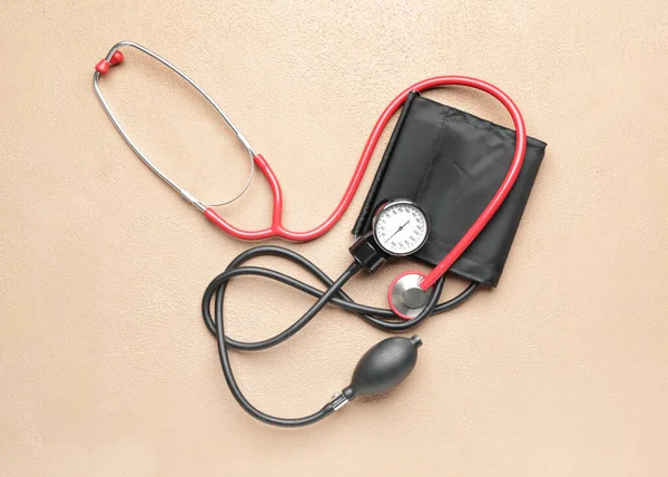 Stethoscope with sphygmomanometer on color background — Stock Photo, Image