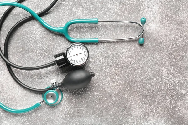 Stethoscope with sphygmomanometer on grey background — Stock Photo, Image