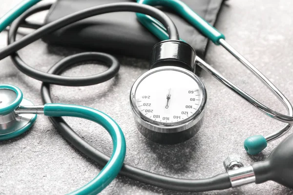 Stethoskop mit Blutdruckmessgerät auf grauem Hintergrund — Stockfoto