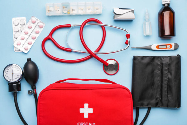 Комплект первой помощи на цветном фоне