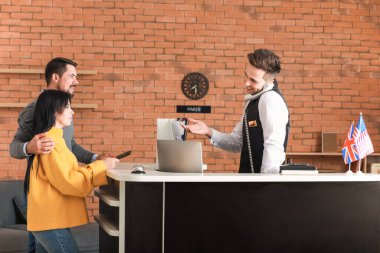 Couple booking room in hotel at reception