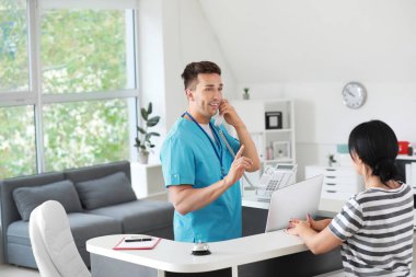 Klinikte hastayla çalışan bir resepsiyonist.