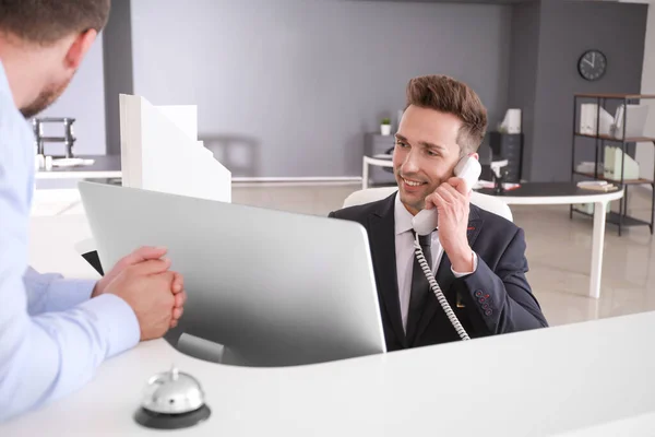 Empfangsdame arbeitet mit Besucher im Büro — Stockfoto