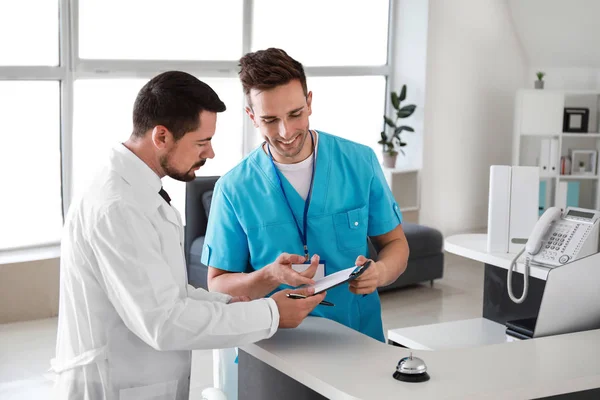 Male receptionist working with doctor in clinic — Stock Photo, Image