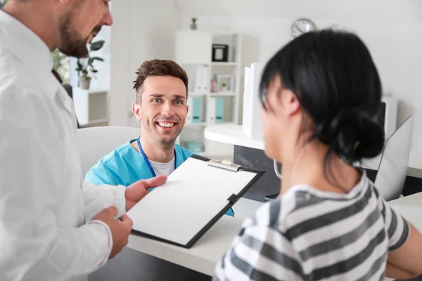 Médecin avec patient près de la réception à la clinique — Photo