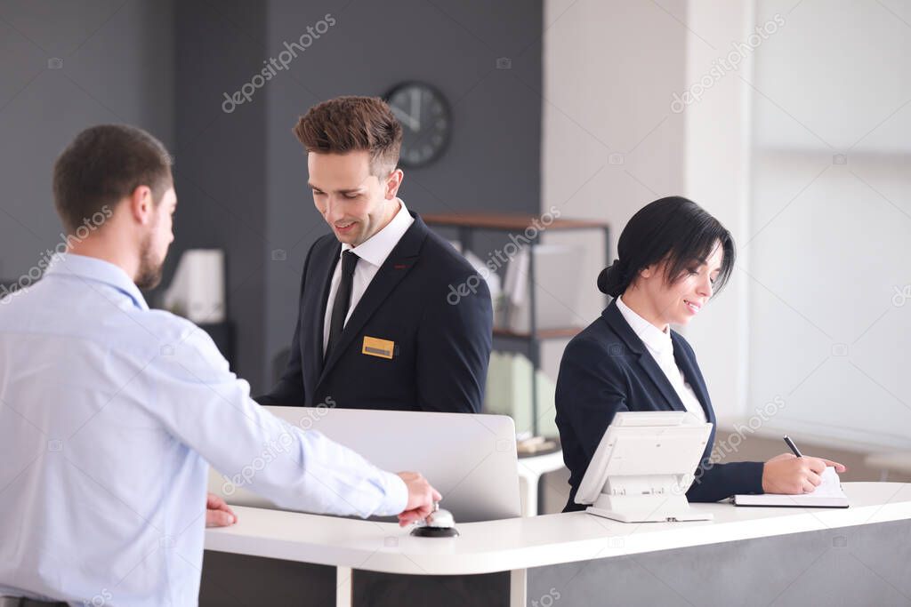 Receptionists working with visitor in office