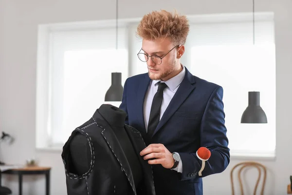 Young tailor working with mannequin in atelier — Stock Photo, Image
