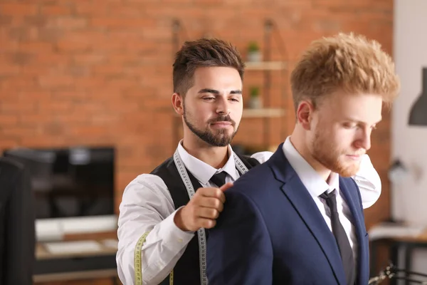 Male tailor taking client's measurements in atelier — Stock Photo, Image
