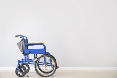 Işık duvarının yanındaki boş tekerlekli sandalye.