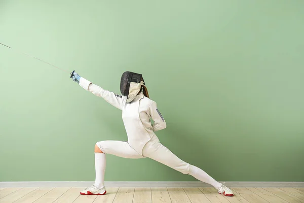 Young female fencer against color wall — Stock Photo, Image