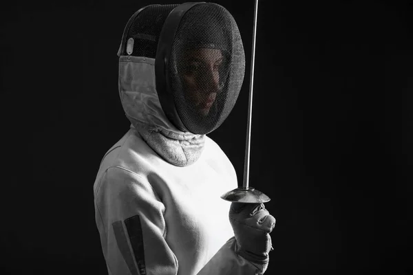 Joven esgrimista femenino sobre fondo oscuro — Foto de Stock