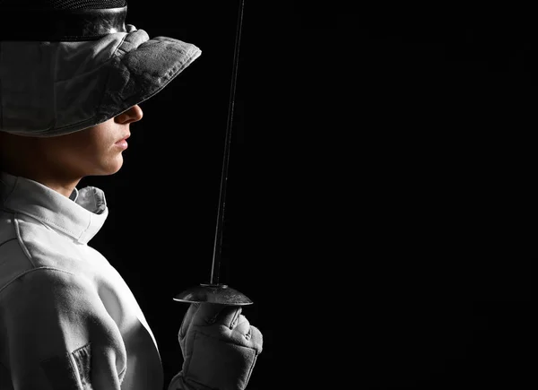 Jovem esgrimista feminina no fundo escuro — Fotografia de Stock