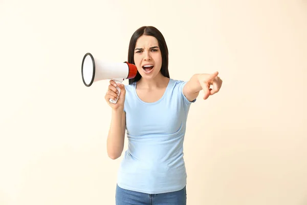 Emotional woman with megaphone on light background. Concept of feminism — Stock Photo, Image