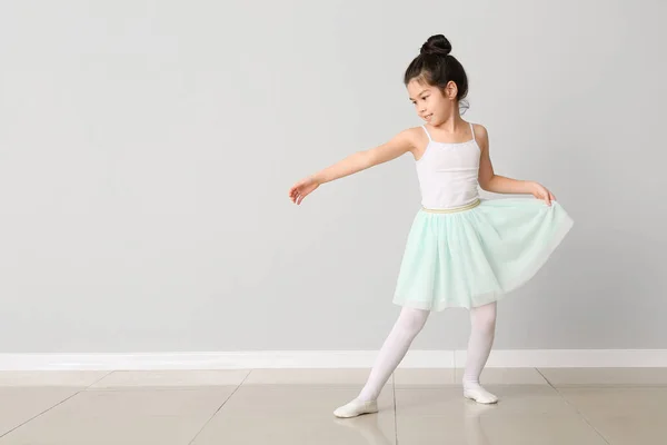 Cute little ballerina against light wall — Stock Photo, Image