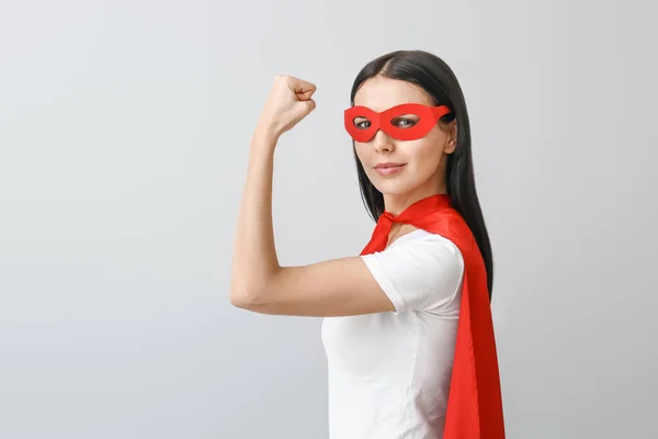 Mujer en traje de superhéroe sobre fondo gris. Concepto de feminismo — Foto de Stock
