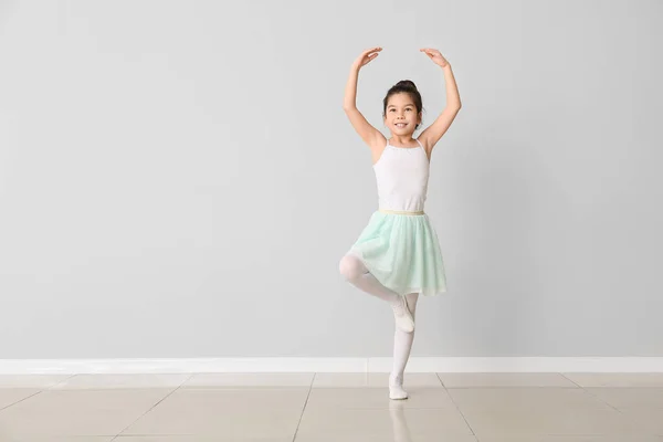 Симпатичная маленькая балерина у светлой стены — стоковое фото