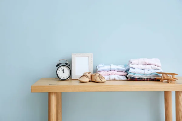 Babykleding op tafel in de kamer — Stockfoto