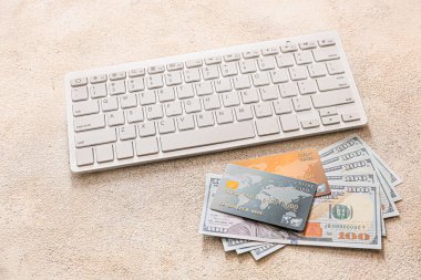 Gri arka planda para ve bilgisayar klavyesi olan kredi kartları. Çevrimiçi bankacılık kavramı