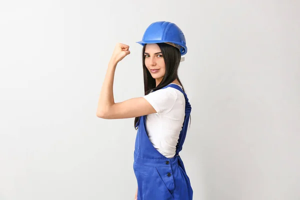 Vrouwelijke werkneemster tegen lichte achtergrond. Begrip feminisme — Stockfoto