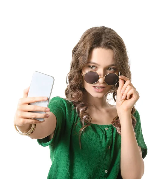 Ung kvinna som tar selfie på vit bakgrund — Stockfoto
