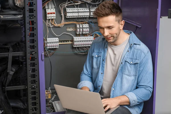 Technician engineer with laptop in server room