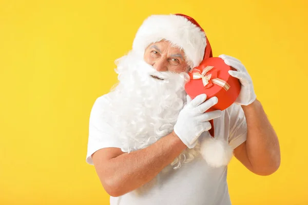 Santa Claus s dárkem na barevném pozadí. Koncept dovolené — Stock fotografie
