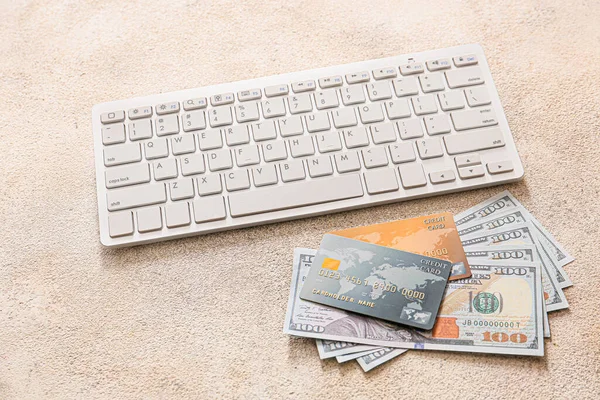 Cartões de crédito com dinheiro e teclado de computador em fundo cinza. Conceito de banco online — Fotografia de Stock