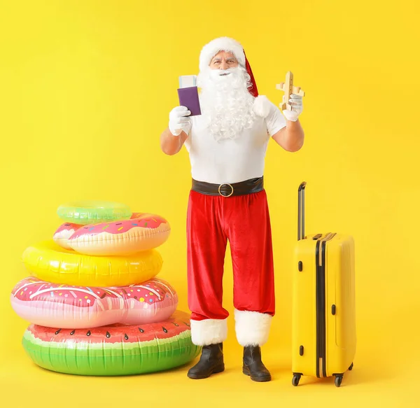 Santa Claus con equipaje sobre fondo de color. Concepto de vacaciones — Foto de Stock