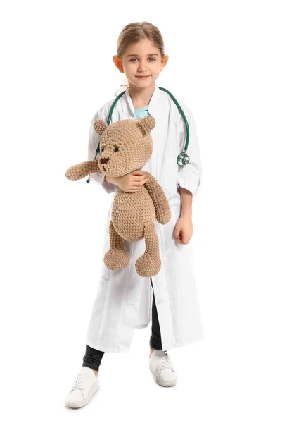 Cute little doctor with toy on white background — Stock Photo, Image