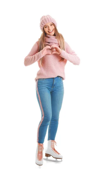 Mooie jonge vrouw op schaatsen maken hart met haar handen tegen witte achtergrond — Stockfoto