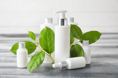 Ahşap masadaki şişelerde farklı kozmetik ürünler.