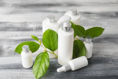 Ahşap masadaki şişelerde farklı kozmetik ürünler.